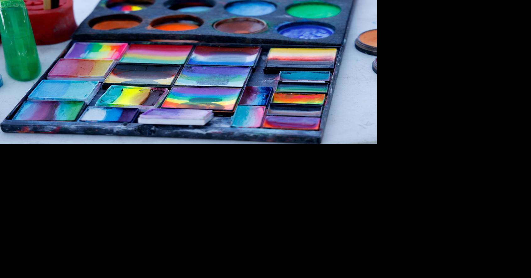Paints sit open at the face painting table News