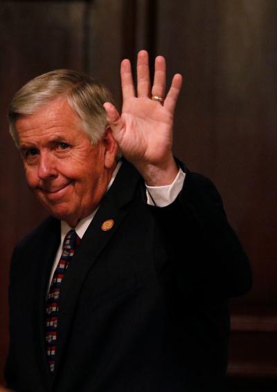 Mike Parson waves to the media
