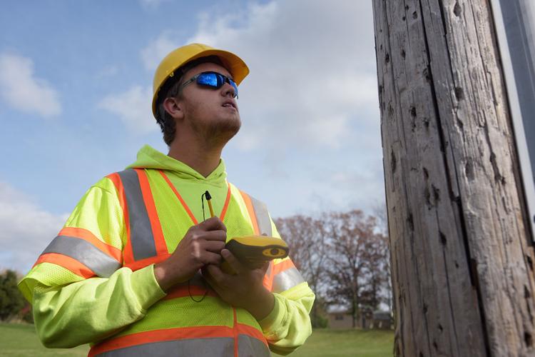 Ben Lee inspects a utility pole