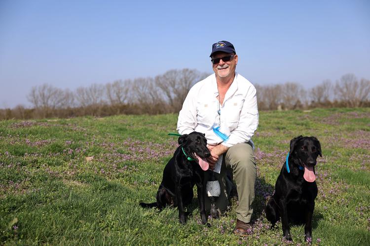 Rip Shively poses for a portrait with his dogs, Ruthie and Katie