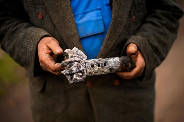 A local resident holds ammunition found in his destroyed house