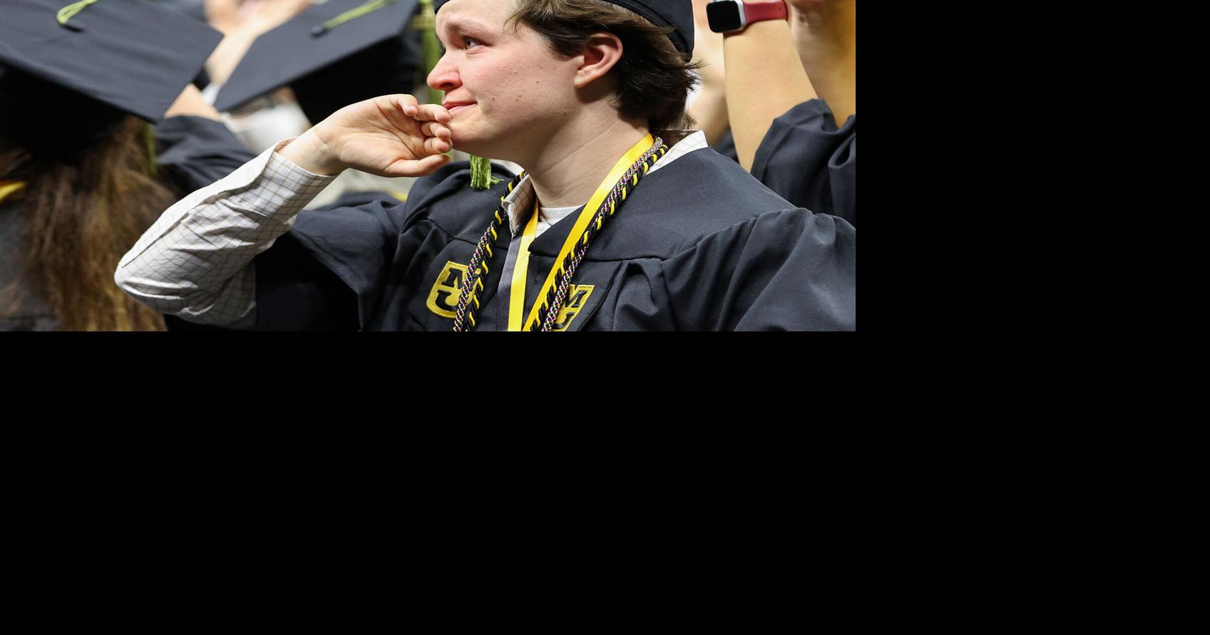 Avery Adams wipes a tear as graduates wave to family and friends