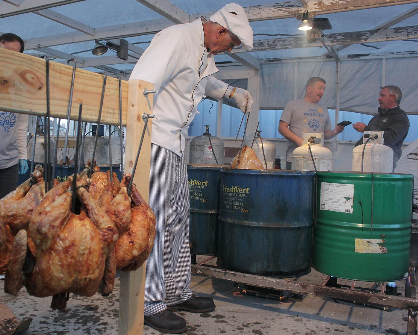 Marty Walker, a member of the Rotary Club of Columbia, checks the temperature of the turkeys as they fry in barrels of oil