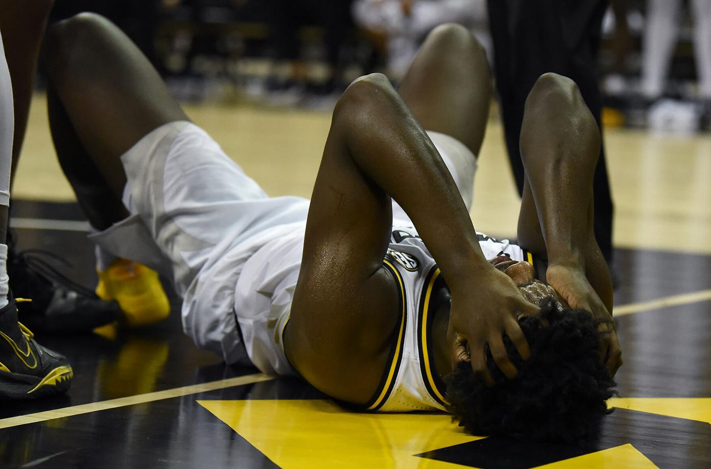 Missouri forward Kobe Brown holds his head after hitting the ground
