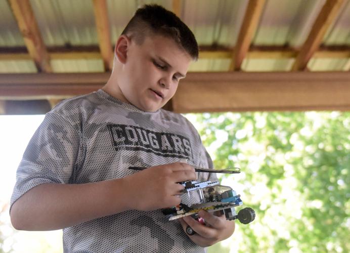 Caleb Ortbals, 11, reattaches a piece to his Lego helicopter