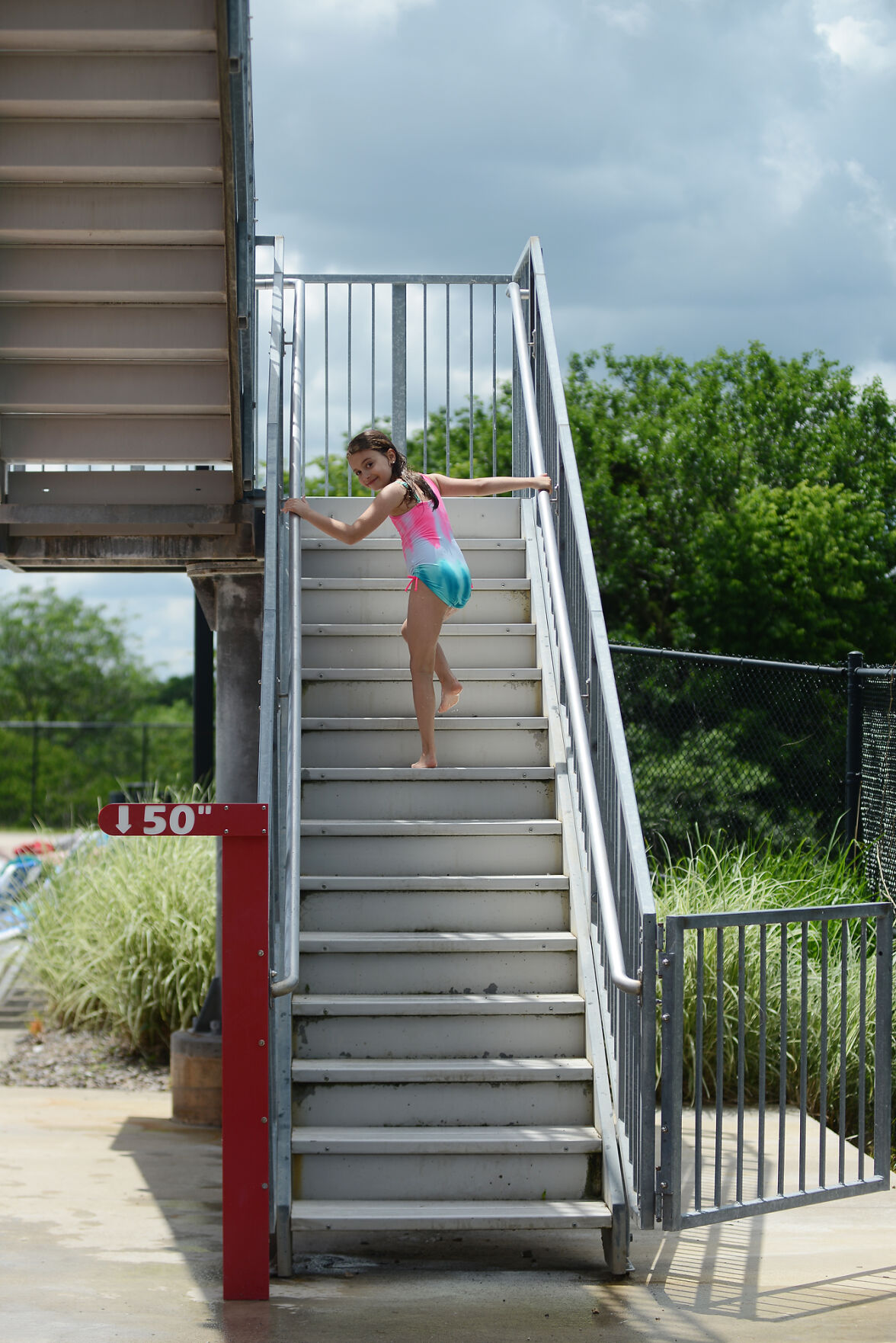 Taylor Trask climbs up the pool slide stairs News