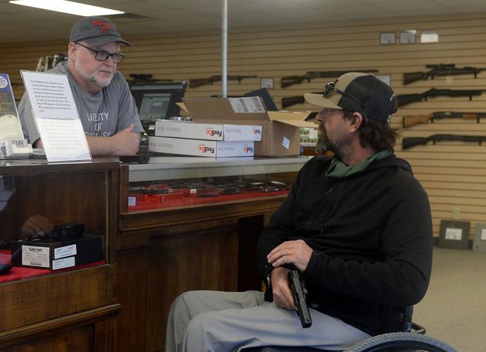 James Hanson, right, checks out a handgun