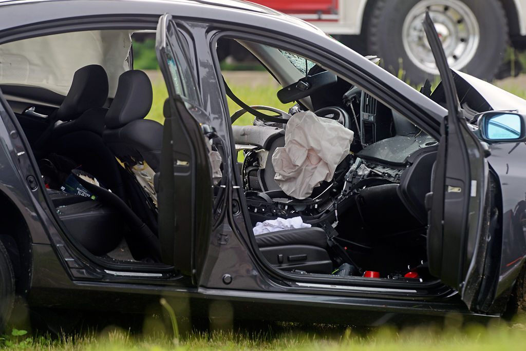 A car sits in a ditch after being struck by a fleeing truck