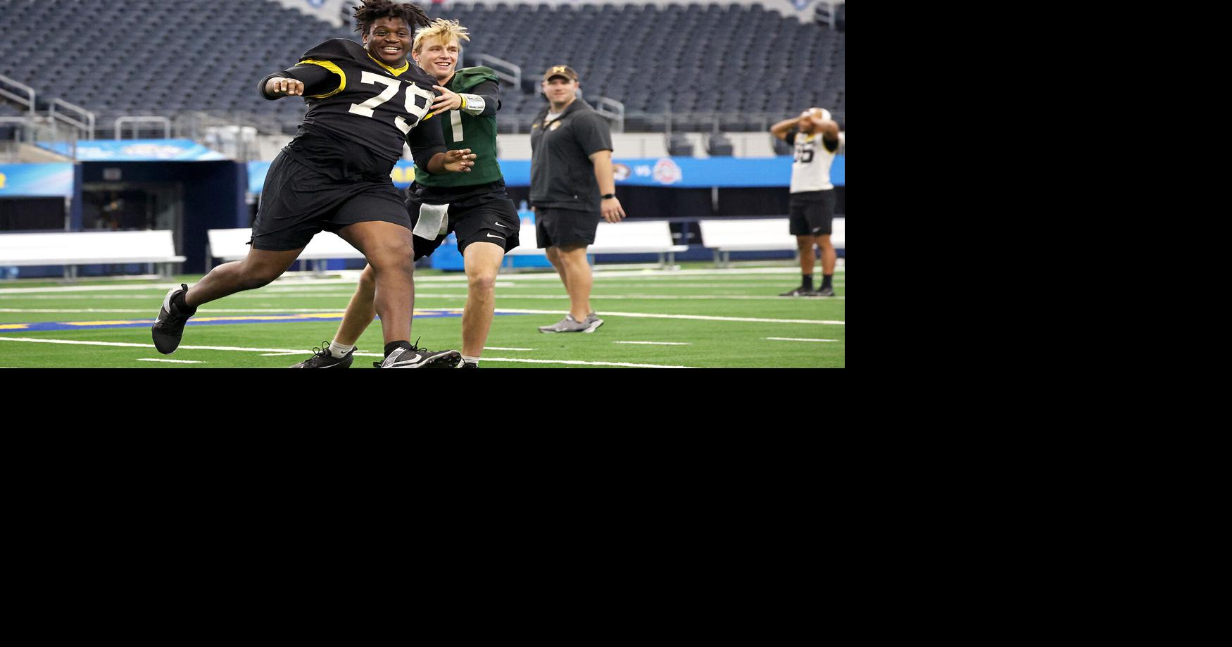 Missouri offensive lineman Armand Membou, left, tries to pass