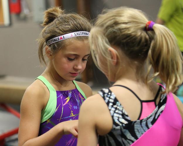 9-year-old Melinda Olson chats with fellow gymnast