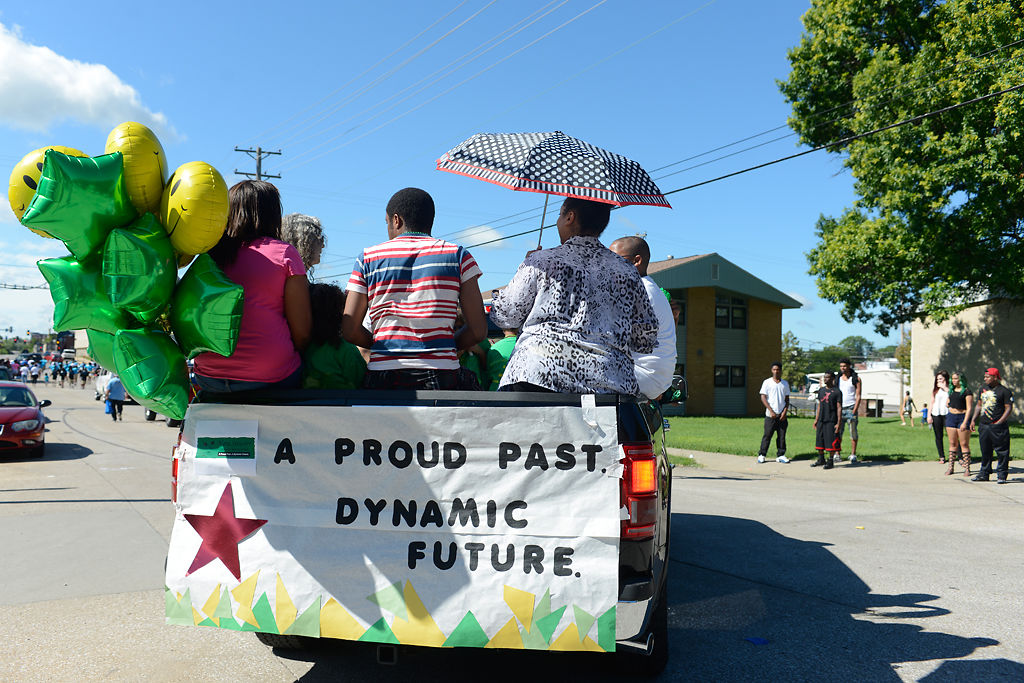 People sit on the back of the Nora Stewart Early Learning Center float