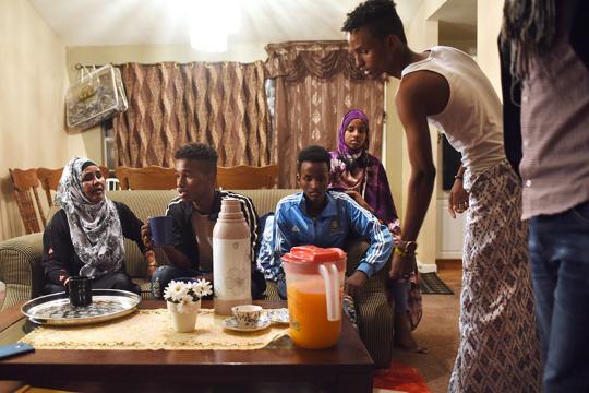 The Abdirahman family sign paperwork from their case worker