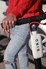 Joshua Thomas rests on a Bird scooter