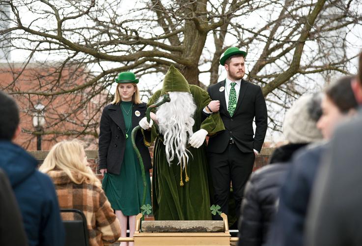 From left, Kate Sherard, an actor portraying St. Patrick, and Lane Atchison stand in front of the “Erin Go Bragh” stone during the Knighting Ceremony and Grand Kowtow
