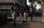 Makayla Houser, Joshua Thomas and Justin Glenn ride Bird scooters