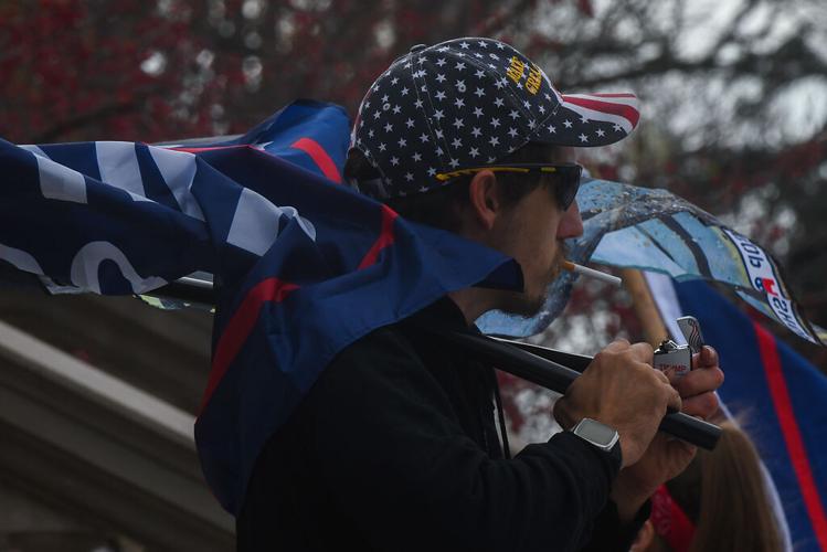 President Donald Trump supporter Chris Surface lights a cigarette with a Trump lighter