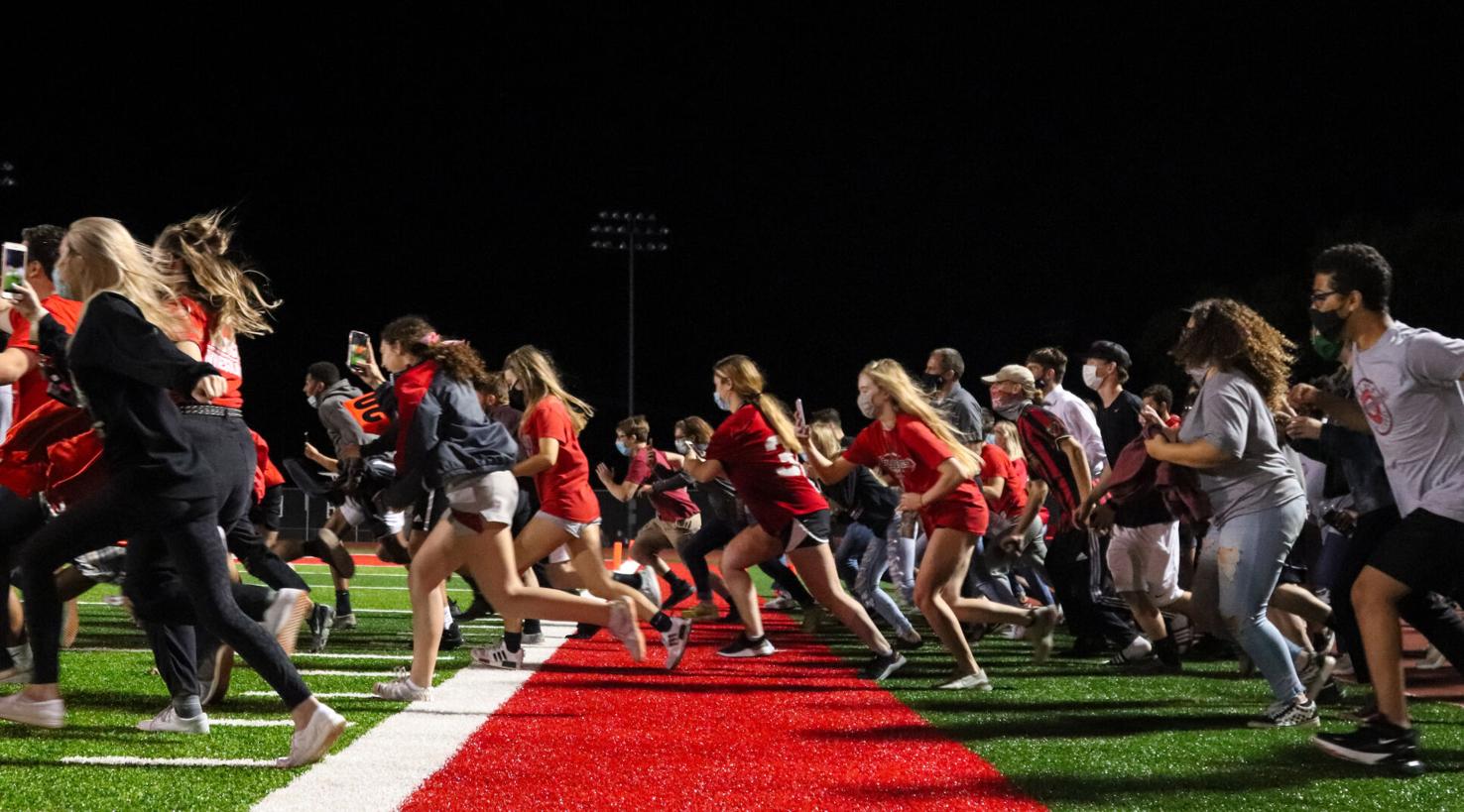 Mexico High School class of 2021 rush the football field after their