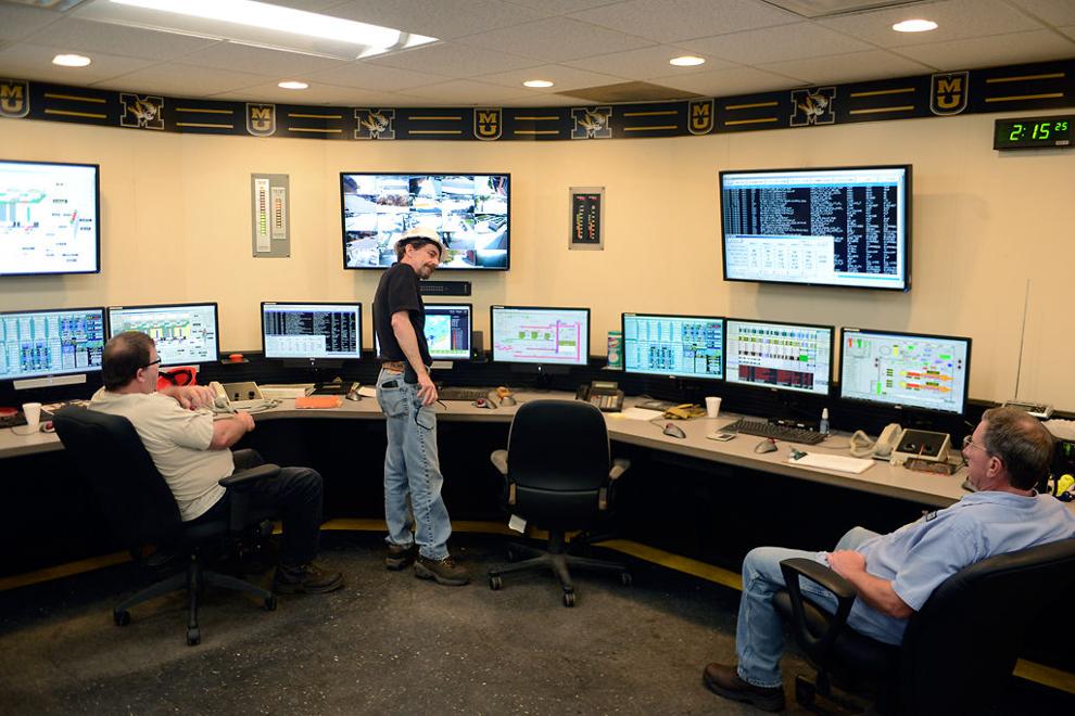 Power plant employees work in the control room Photos