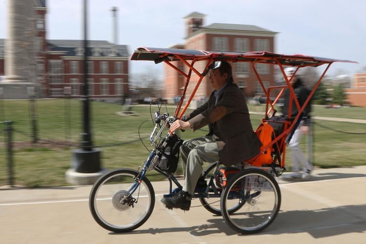 Bin Wu sits in his solar-powered bike