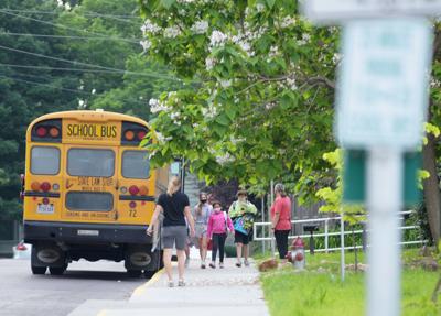 Students exit the bus and walk into Locust Street Expressive Arts Elementary School