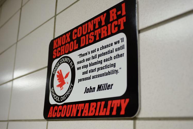 A sign hangs on a wall outside of the room where a school board meeting was held