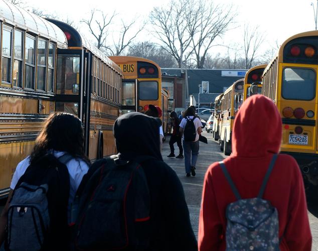 High school students walk toward the buses after school