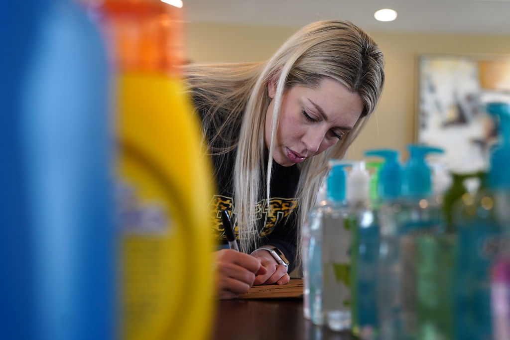 Cortney Gilbow, a Beulah Ralph Outreach Committee member, writes down the information about families