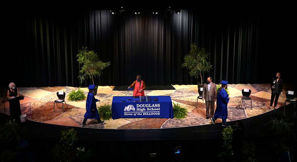 Graduates step onto the stage to take the diploma and take a picture