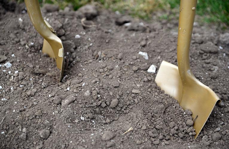 Ceremonial shovels sit in the dirt