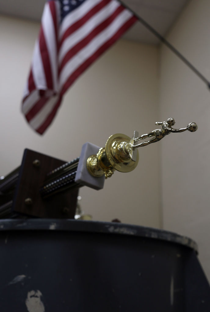 Trophies sit piled into a trash bin
