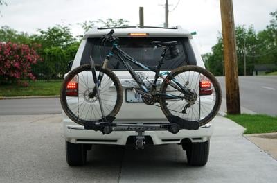 An SUV with a mud-covered bicycle