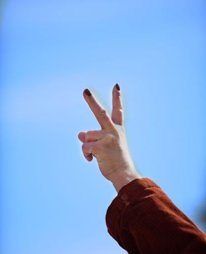 A demonstrator raises the peace sign to motorists
