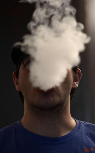 A cloud of smoke obscures an MU student's face