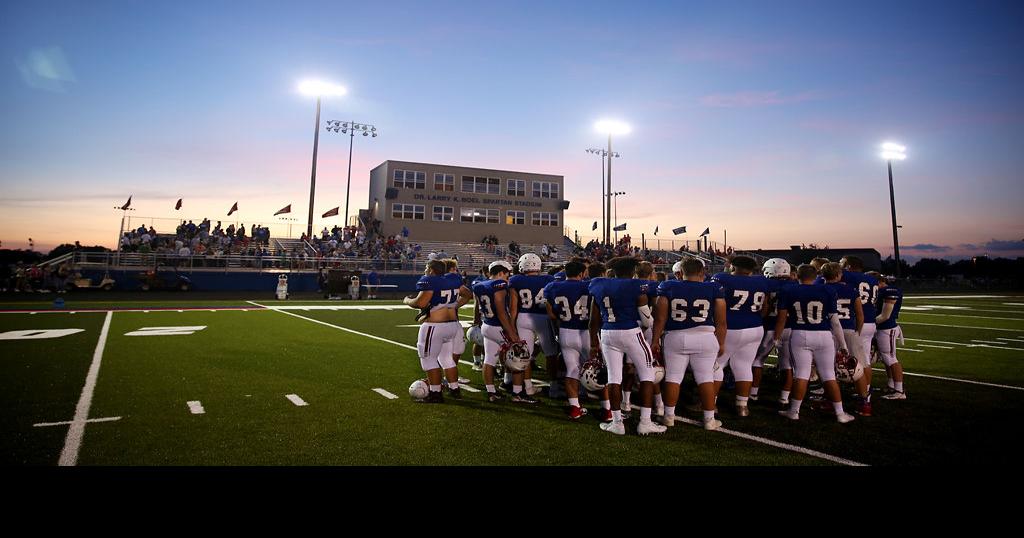 The Moberly High School football team talks in a huddle after the