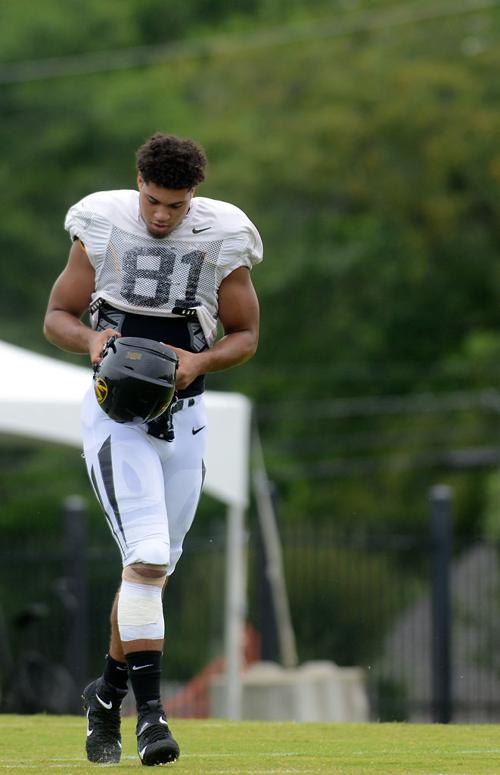 Tight end Albert Okwuegbunam pulls on his helmet before returning drills