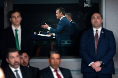 Staff members watch as Defense Secretary Pete Hegseth speaks during a press briefing at the Pentagon on March 2, 2026.