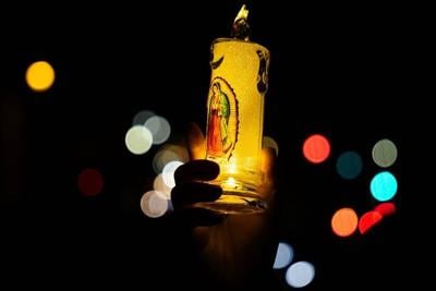 A protester holds up a candle with the image of La Virgen de Guadalupe while marching in Los Angeles during a January 2026 vigil in solidarity with immigrants facing raids in Minneapolis.