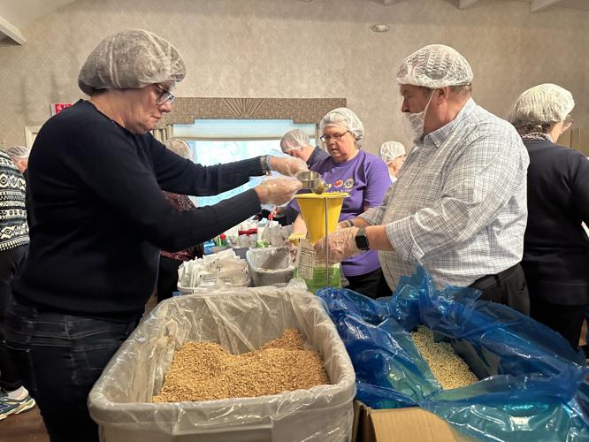Lions Club International members volunteer Oct. 25 at a breakfast meal packaging