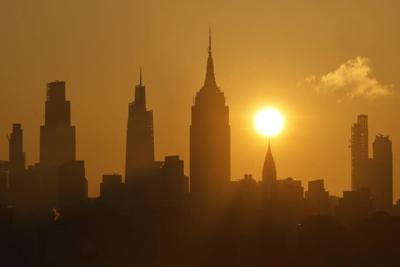 The sun rises over New York City as a heat wave arrives in June 2025.