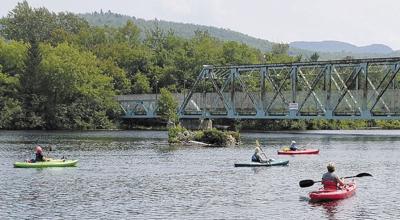 Kayakers paddle a section of the Androscoggin River.