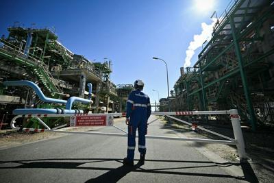 A worker stands at a TotalEnergies refinery in northwestern France.