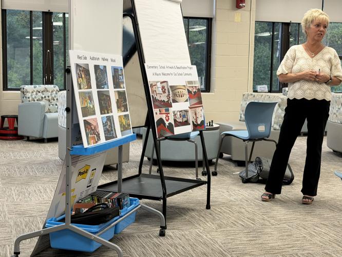 School board secretary Deb Foss speaks of the new murals