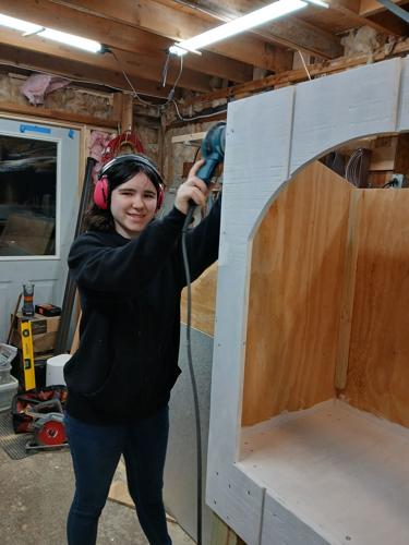 Wednesday Belanger works on the design of the little free pantry