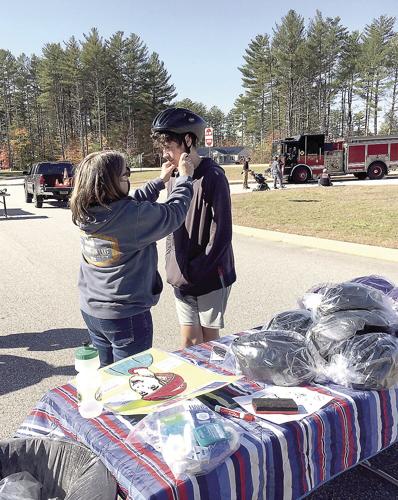 Wheel Family Sun - Bike rodeo - Lisa Baughn adjusts helmet
