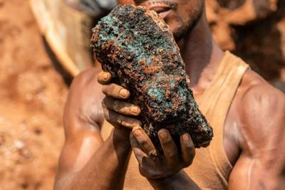 An artisanal miner holds a cobalt stone at a mine near Kolwezi, Congo, in 2022. About 20,000 people work there among toxic materials.