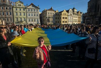 A crowd of people in Prague display a Ukrainian flag as they watch the 'Save Ukraine – Stop War' concert  in 2022.