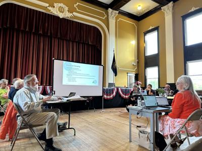 Planning consultant Judi Barrett (right) speaks with Tom McCue (left) during a planning board