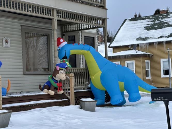 A Christmas tree-eating dinosaur outside a Milan Road home