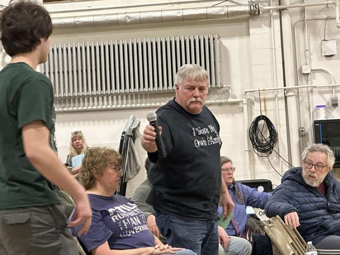 Adam White (standing, center) hands the microphone to a volunteer