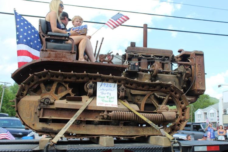 A century-old tractor wends its way during the July 4 parade
